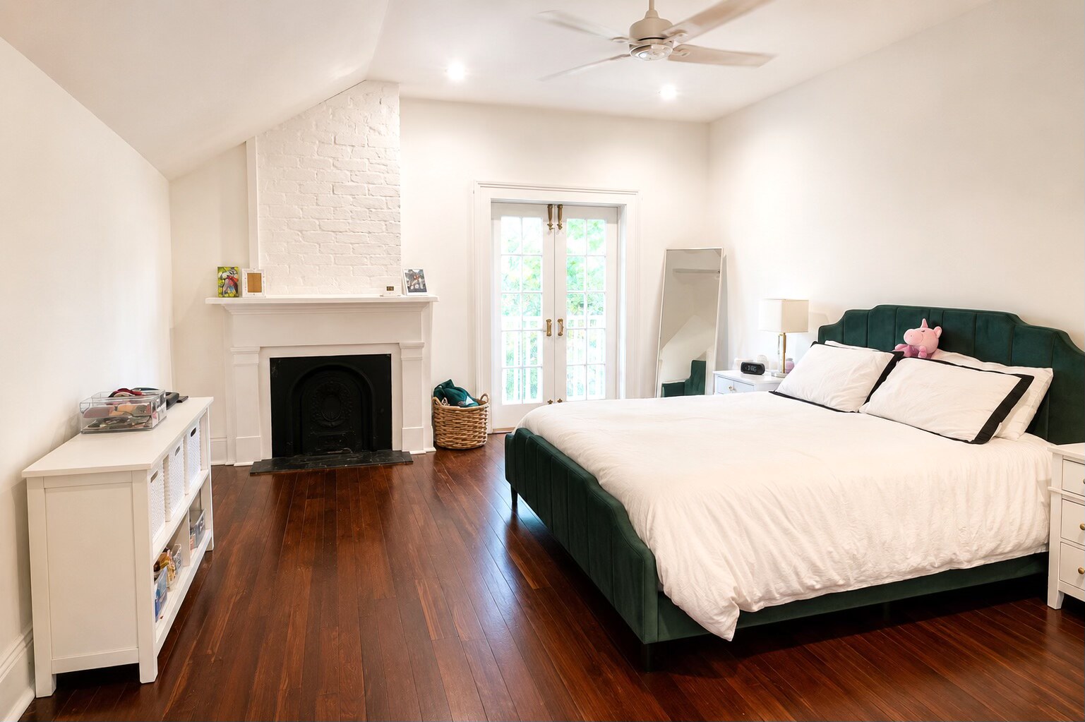 Clean organized master bedroom with fireplace and hardwood floors in New Orleans by Nola Organizers