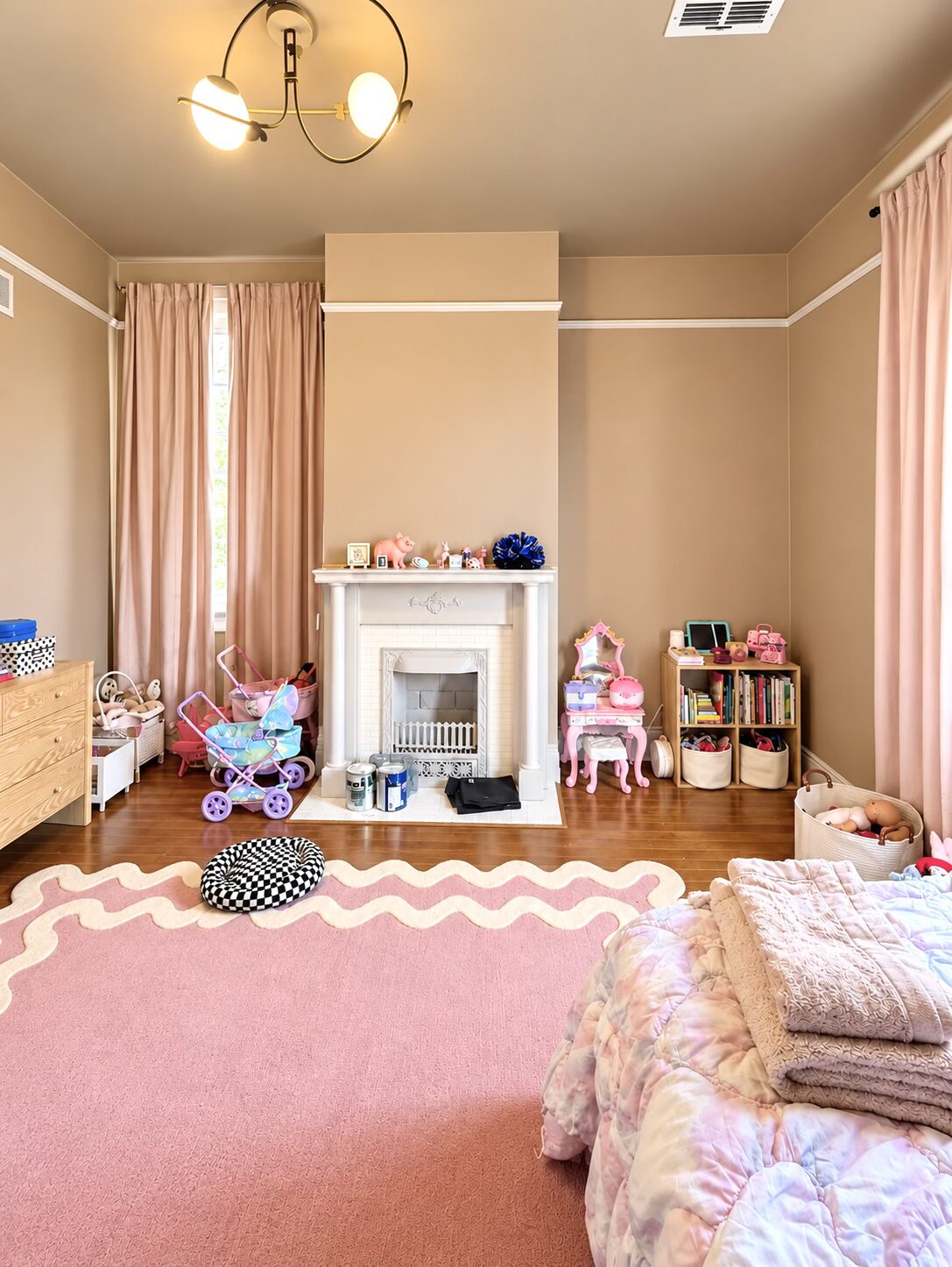 Organized books, toys, and baskets beside the fireplace in the pink bedroom