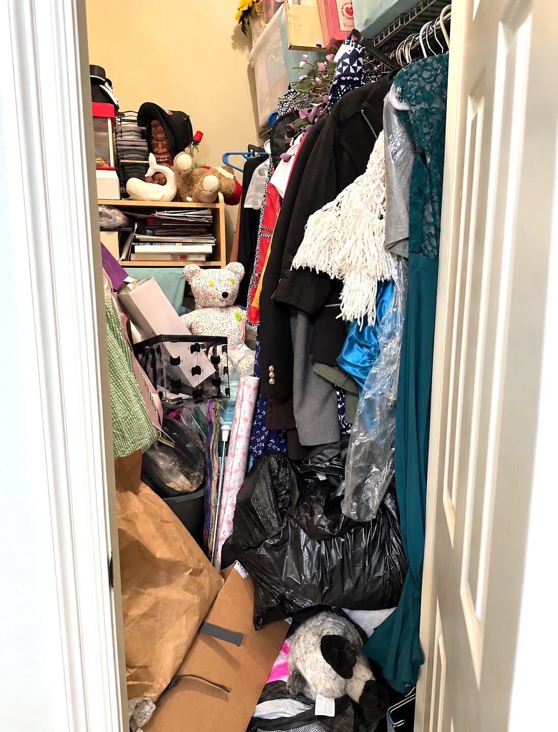 New Orleans closet before decluttering, with clothing, toys, bags, and miscellaneous belongings filling the floor and shelves