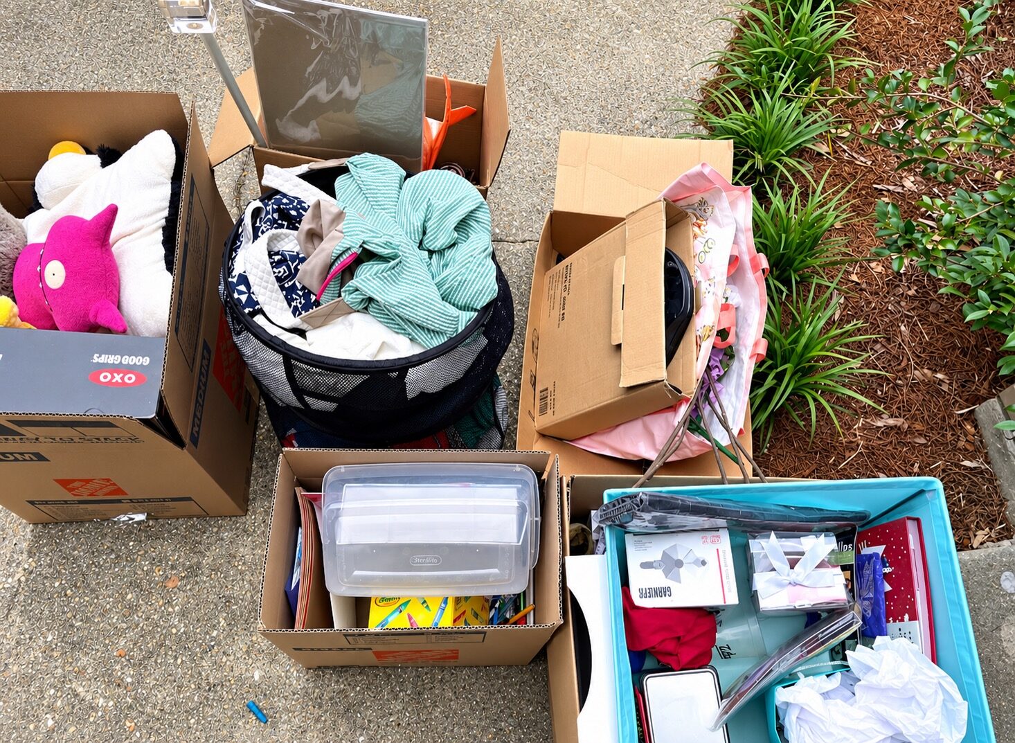 Boxes and containers of clothing, toys, and other belongings selected for donation