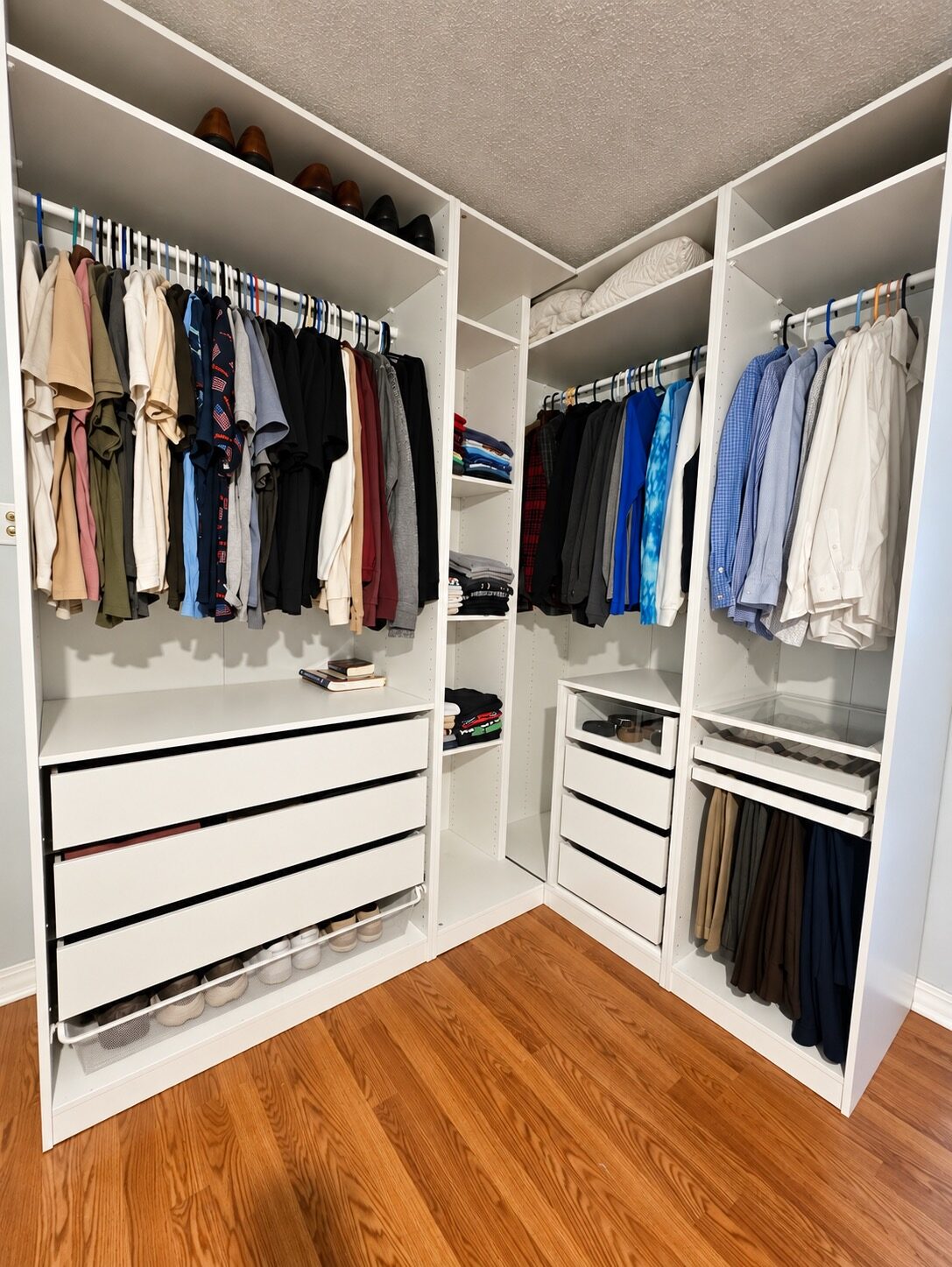 Custom closet in New Orleans after unpacking, with hanging clothes, folded shirts, shoes, and linens