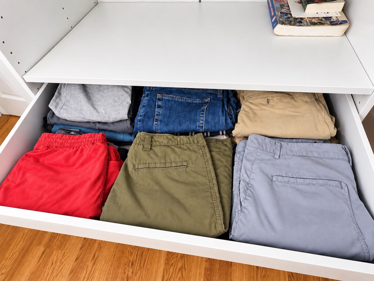 Folded pants and shorts grouped in a closet drawer