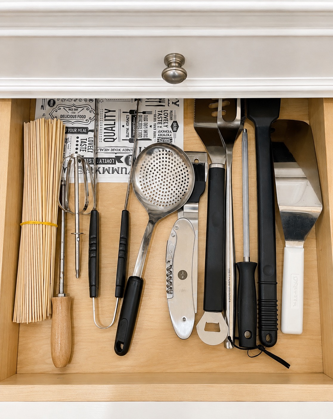 Barbecue utensils grouped in an organized kitchen drawer