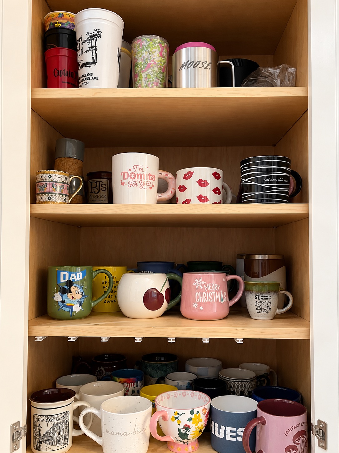 Mugs grouped together in an organized kitchen cabinet