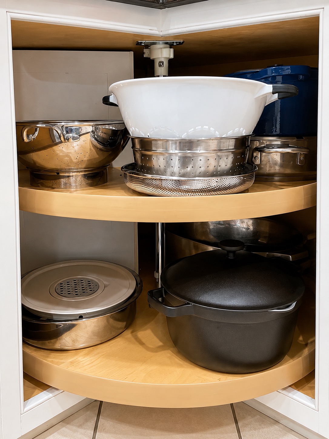 Strainers and bowls grouped together in an organized kitchen cabinet