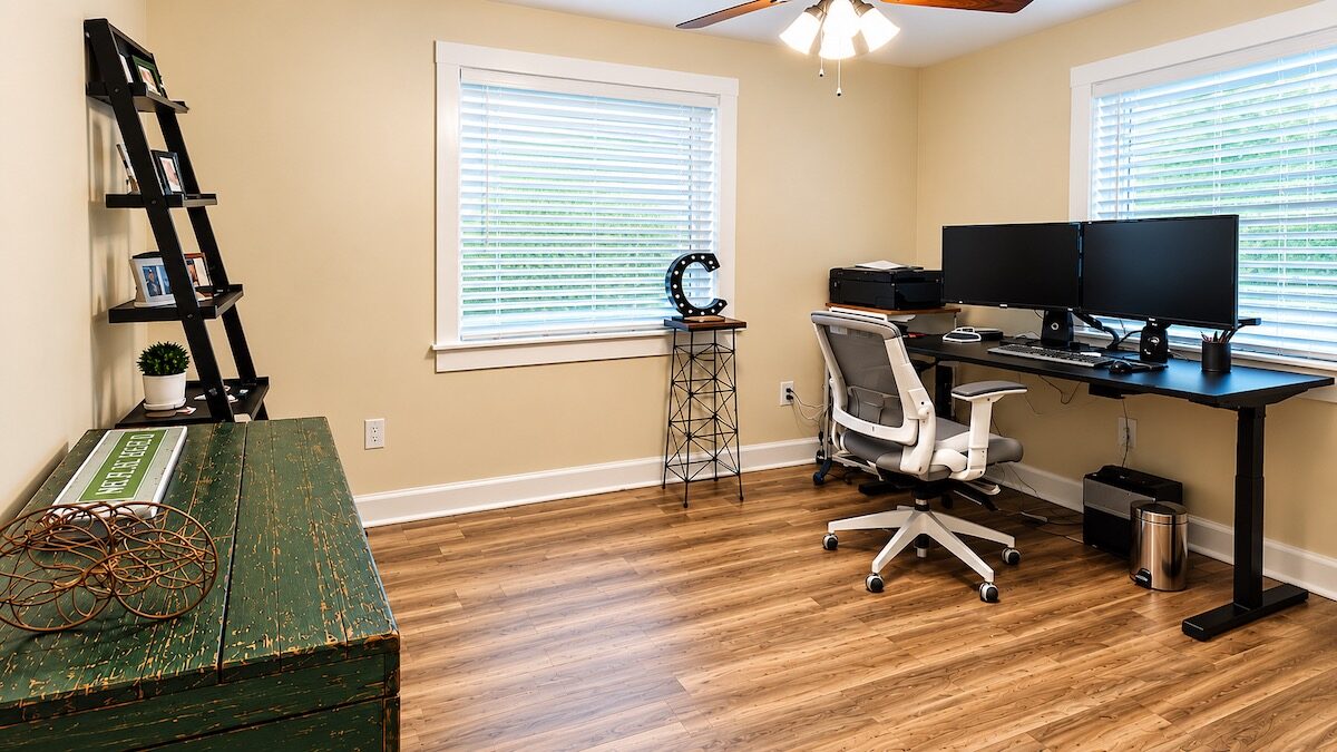 Organized home office with a clear desk, computer setup, and open floor space