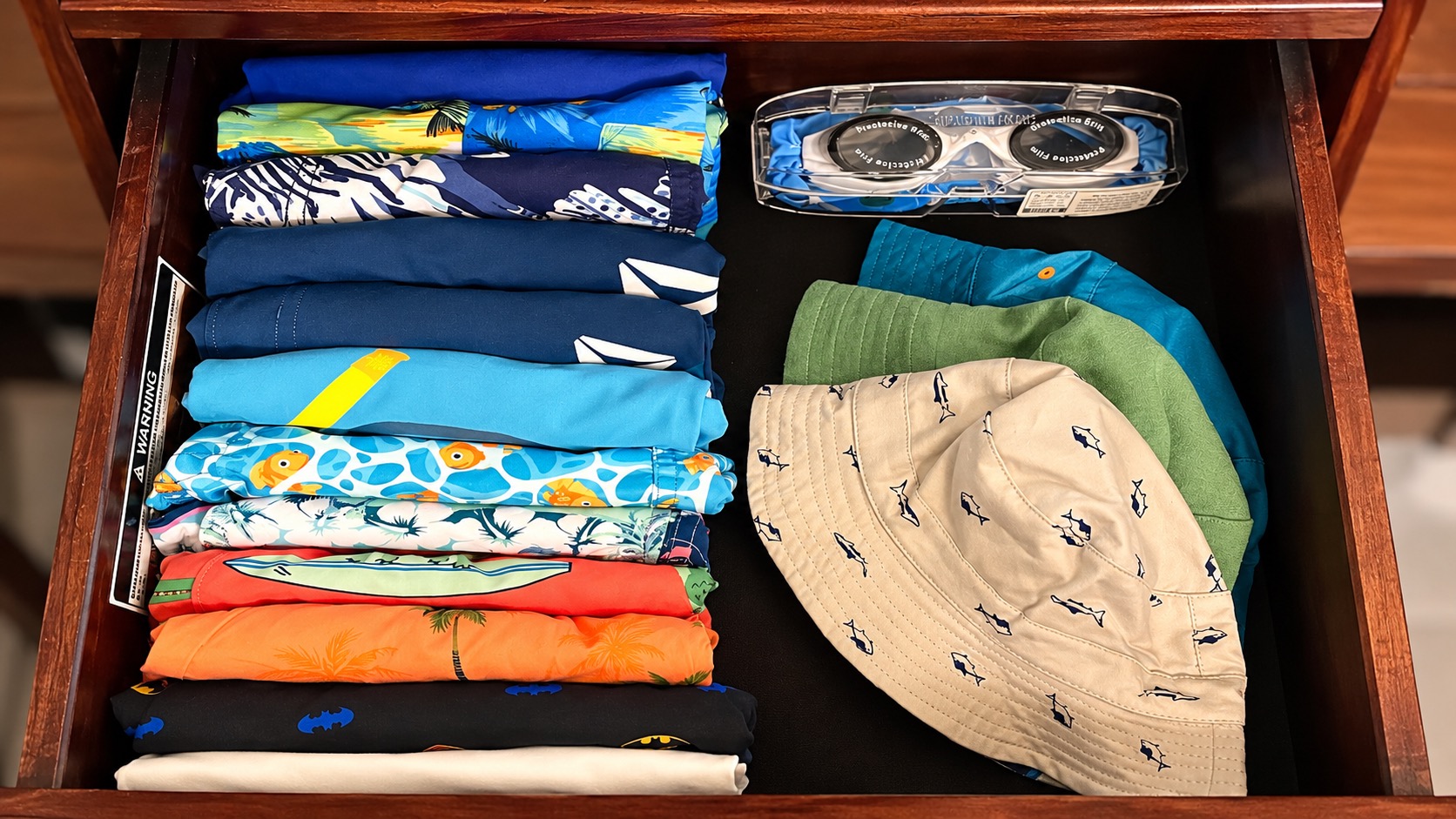 Drawer organizing swimwear, hats, and goggles