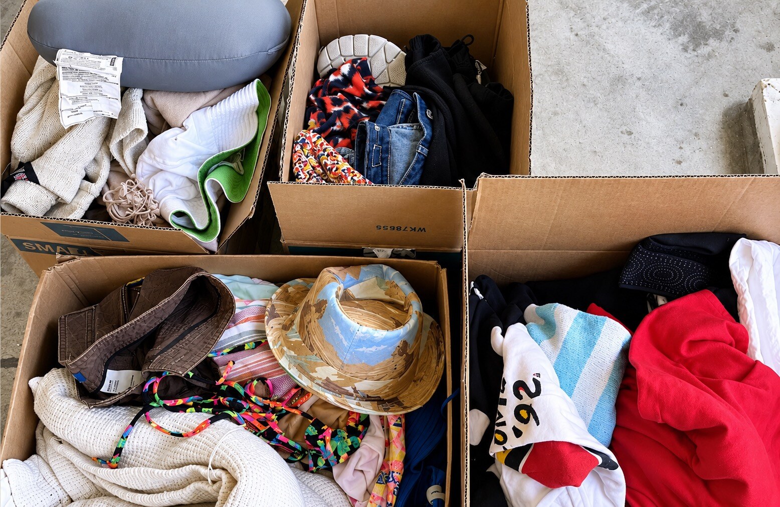 Clothing and household items sorted into boxes during a decluttering session.