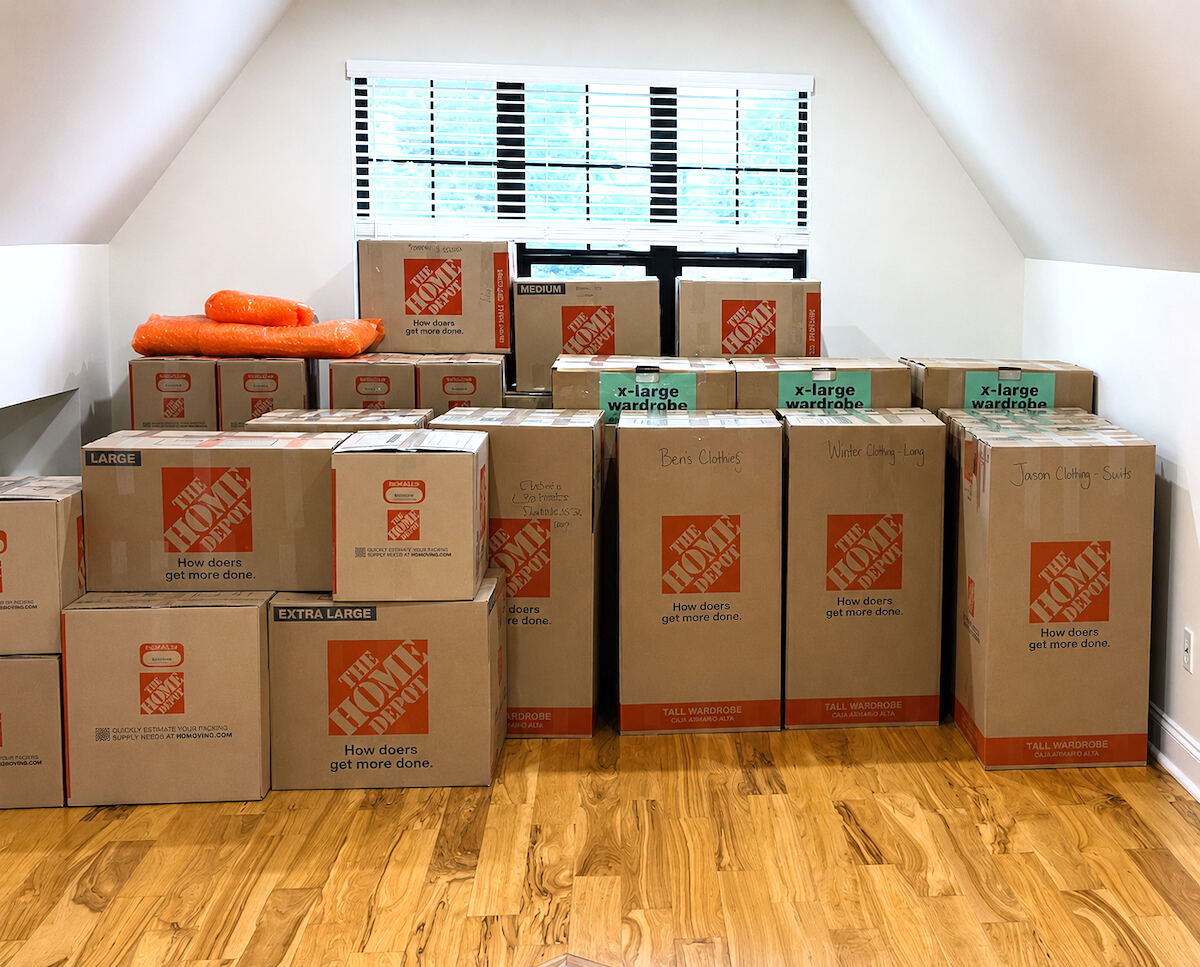 Stacks of labeled moving boxes sorted by room including kitchen, living room, and bath
