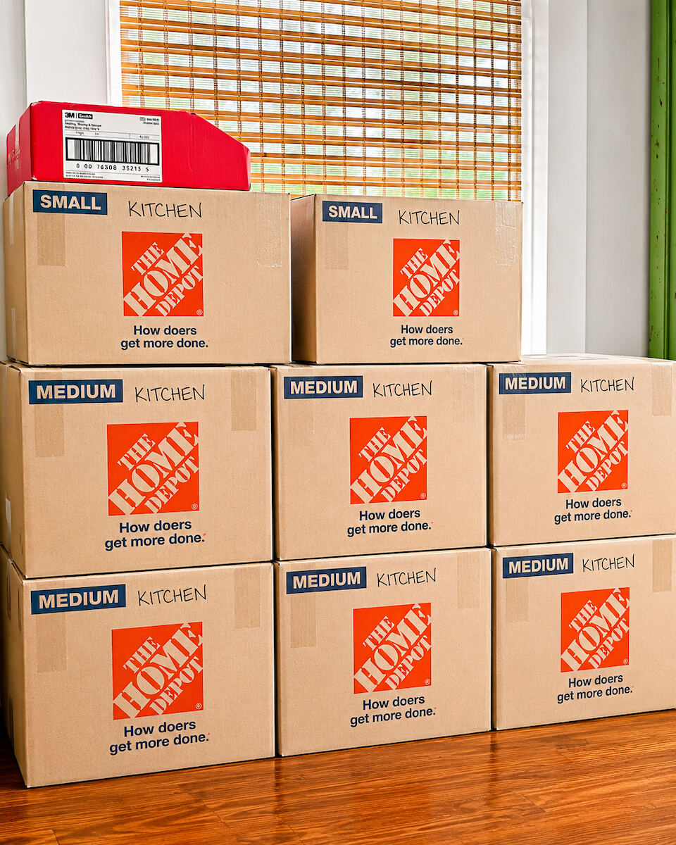 Neatly stacked and labeled moving boxes filling a living room, organized by room for a New Orleans move